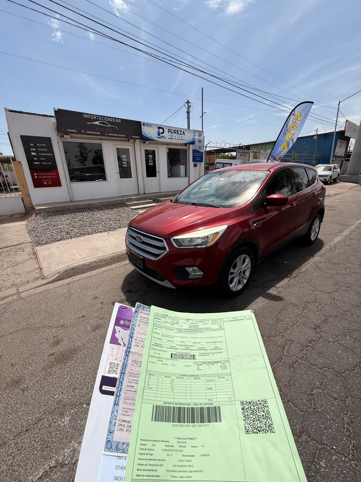Ford rojo frente a la oficina de MR Importaciones, con documentación del trámite