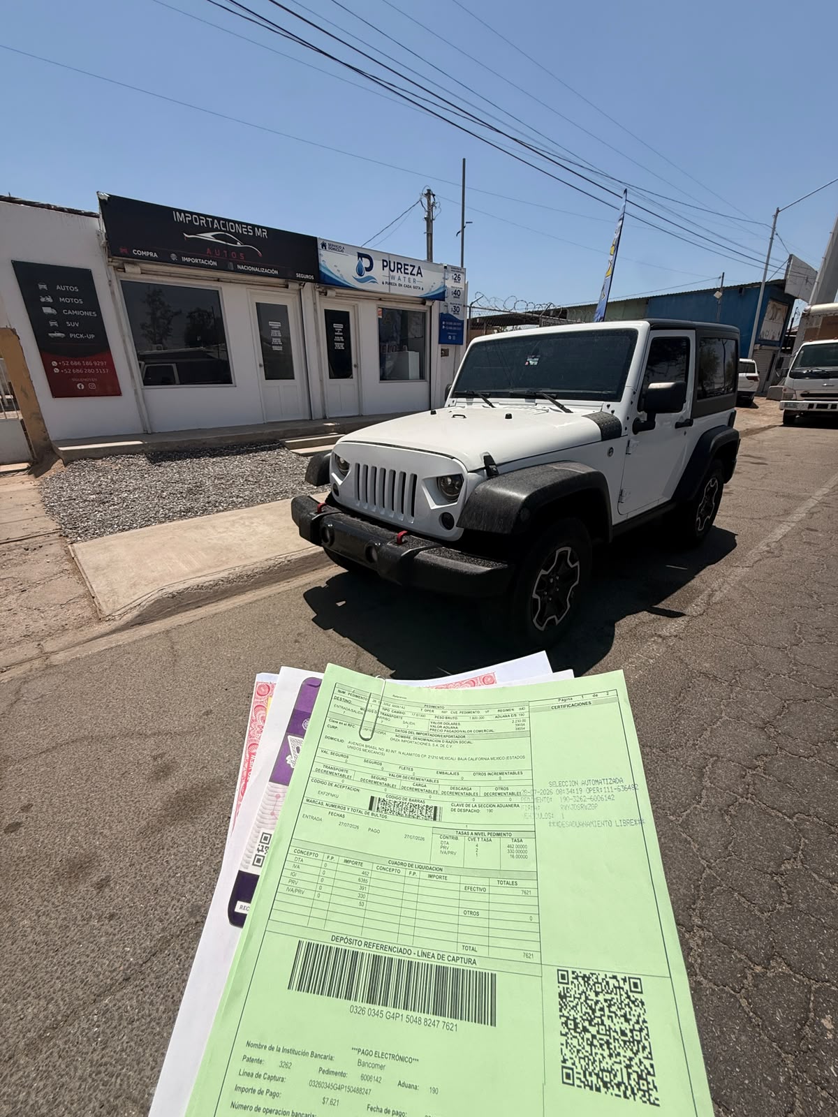 Jeep blanco frente a la oficina de MR Importaciones, con documentación del trámite