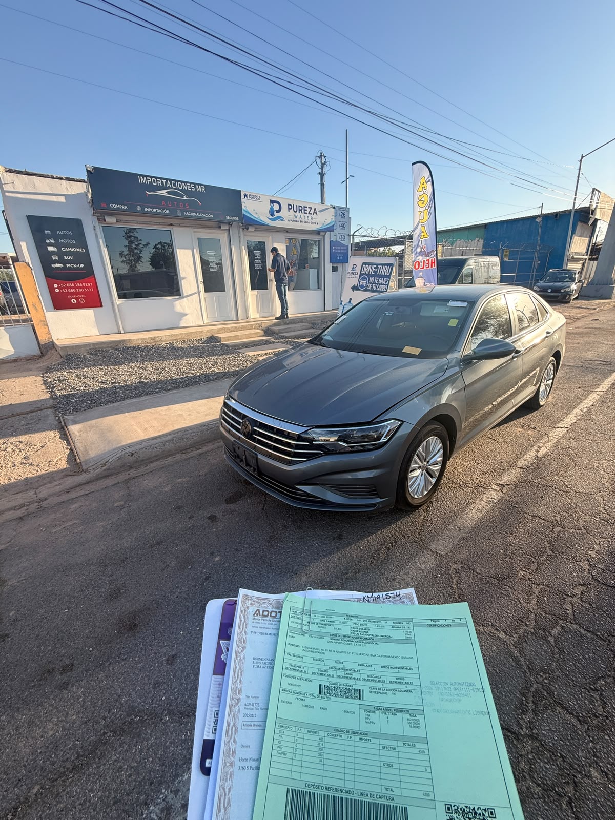Volkswagen gris frente a la oficina de MR Importaciones, con documentación del trámite